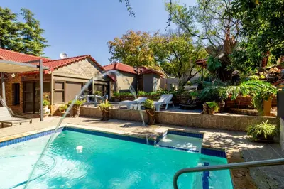 a swimming pool in the backyard of a house at Cheerful Cottage in Johannesburg