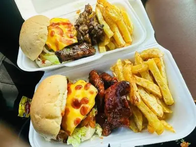 two styrofoam containers of food with a sandwich and french fries at Le Paradise holiday resort in Badplaas