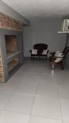 a living room with two chairs and a fireplace at Tswenyane Kruger Riverview Apartments in Marloth Park