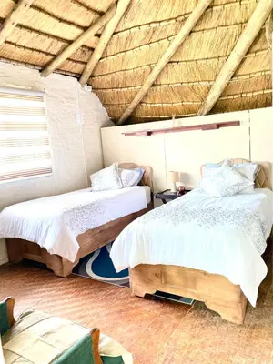 a bedroom with two beds and a wooden ceiling at Pop inn 74 in Midrand