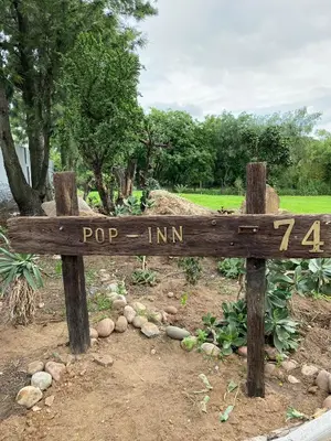 a wooden sign that reads pop inn in a park at Pop inn 74 in Midrand