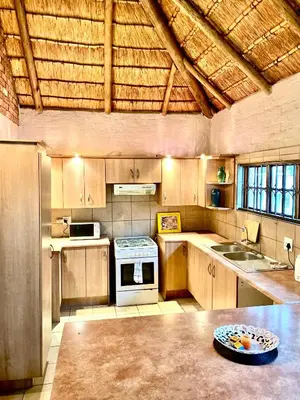a large kitchen with wooden cabinets and a stove at Pop inn 74 in Midrand