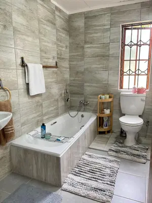 a bathroom with a bath tub and a toilet at Pop inn 74 in Midrand
