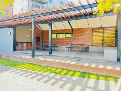 a patio with tables and benches in a brick building at Large 3 Bedroom Apartment in Midrand, Waterfall City - More space than a hotel room - Ideal for families, groups and work trips - 20 Elizabeth Place in Midrand