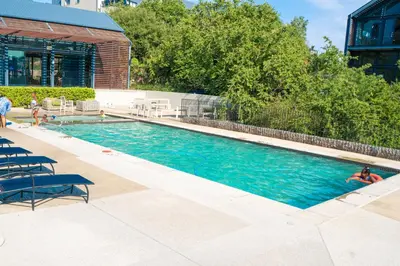 a swimming pool with two people in the water at Large 3 Bedroom Apartment in Midrand, Waterfall City - More space than a hotel room - Ideal for families, groups and work trips - 20 Elizabeth Place in Midrand