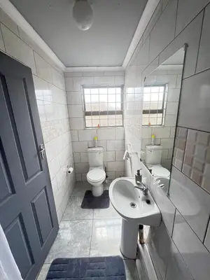 a bathroom with a sink and a toilet and a mirror at Exodus Guesthouse in Driekop