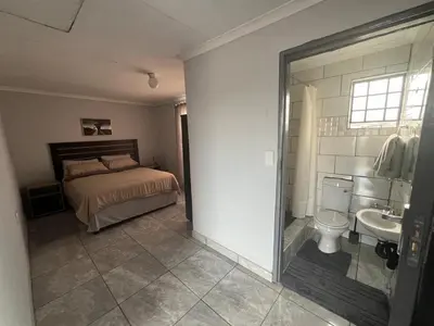 a bedroom with a bed and a toilet and a sink at Exodus Guesthouse in Driekop