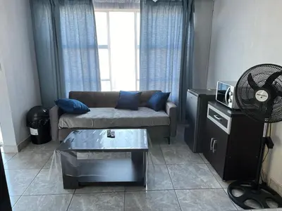 a living room with a couch and a table at Exodus Guesthouse in Driekop