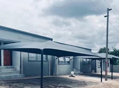 a large blue umbrella in front of a building at Exodus Guesthouse in Driekop