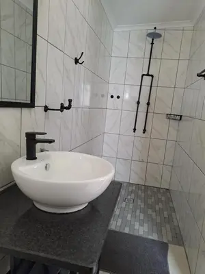 a bathroom with a white sink on a counter at Rustic Farm Stay in Lydenburg