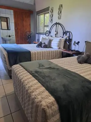 a hotel room with two beds and a bathroom at Rustic Farm Stay in Lydenburg