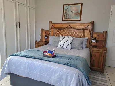 a bedroom with a bed with a tray of food on it at Rustic Farm Stay in Lydenburg