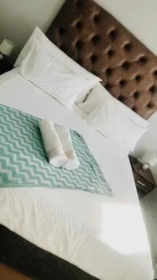 a bed with two towels and two pillows on it at Menlyn Place Vacay in Pretoria