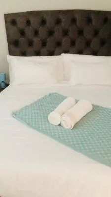 two rolled towels sitting on top of a bed at Menlyn Place Vacay in Pretoria