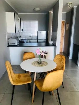 a kitchen with a table and chairs with a table and flowers at Menlyn Place Vacay in Pretoria