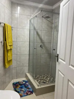 a bathroom with a shower with a glass door at The Garden Haven in Midrand