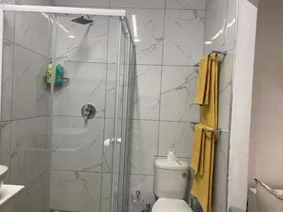 a bathroom with a shower with a toilet at The Garden Haven in Midrand