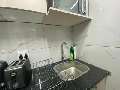 a kitchen counter with a sink and a toaster at The Garden Haven in Midrand