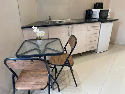 a table and chairs in a kitchen with a sink at The Garden Haven in Midrand