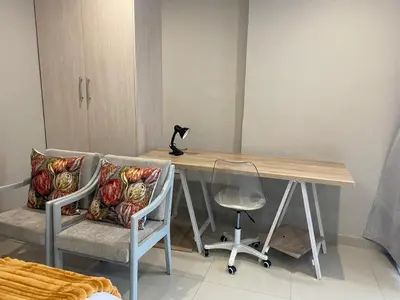 a desk with two chairs and a lamp on top of it at The Garden Haven in Midrand