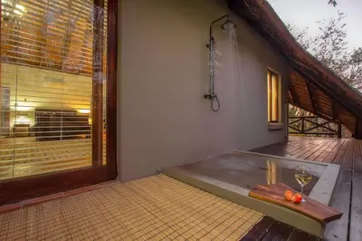 a bath tub in a room with a window at Luxury GuesthouseCo HoneymoonHouse in Marloth Park