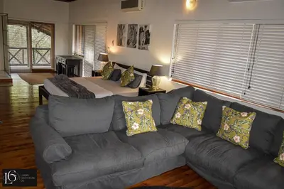 a living room with a couch and a bed at Luxury GuesthouseCo HoneymoonHouse in Marloth Park