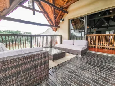 a screened in porch with a couch and a table at Sunshine Retreat @ Zebula in Mabula