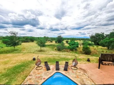 a swimming pool with a view of a field at Sunshine Retreat @ Zebula in Mabula