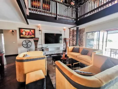 a living room with couches and a tv at Sunshine Retreat @ Zebula in Mabula
