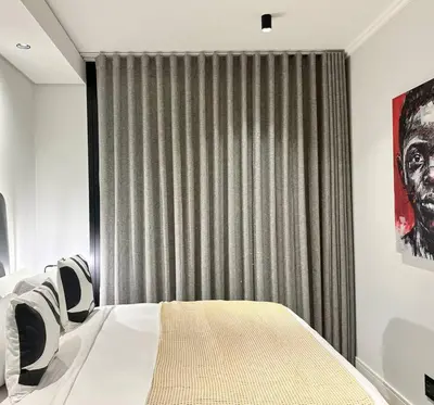 a bedroom with a bed in front of a window at Explore Ellipse - Nguni Room in Midrand