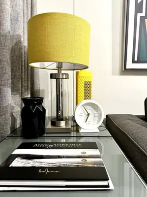 a glass table with a lamp and a clock on it at Explore Ellipse - Nguni Room in Midrand