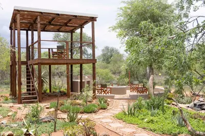 a garden with a wooden pavilion with tables and chairs at Afrikaya Villas in Hoedspruit