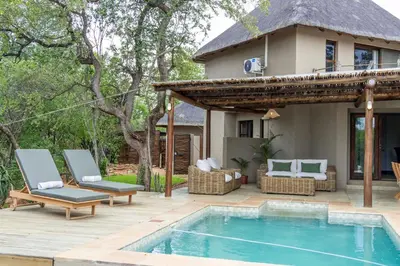 a backyard with a swimming pool and a house at Afrikaya Villas in Hoedspruit