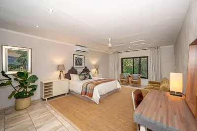 a bedroom with a bed and a living room at Nokuthula Bush Retreat in Marloth Park