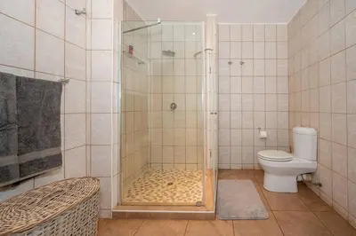 a bathroom with a shower and a toilet at Nokuthula Bush Retreat in Marloth Park