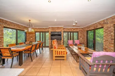 a dining room with tables and chairs and a brick wall at Nokuthula Bush Retreat in Marloth Park
