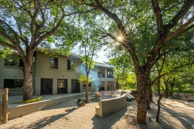 a building with trees in front of it at Nokuthula Bush Retreat in Marloth Park