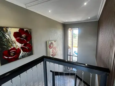 a staircase with two paintings on the wall and a balcony at Sasavona Luxury Cottage - 631 Euphoria Golf & Lifestyle Estate in Naboomspruit