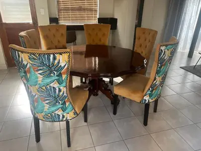 a dining room table with four chairs and a wooden table at Sasavona Luxury Cottage - 631 Euphoria Golf & Lifestyle Estate in Naboomspruit