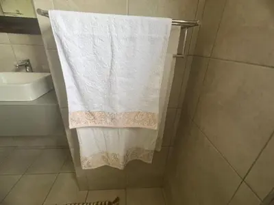 a bathroom with a white towel hanging from a shower at Sasavona Luxury Cottage - 631 Euphoria Golf & Lifestyle Estate in Naboomspruit