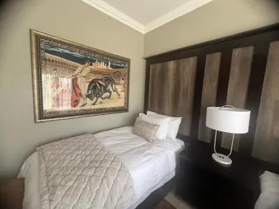 a bedroom with a bed and a painting on the wall at Sasavona Luxury Cottage - 631 Euphoria Golf & Lifestyle Estate in Naboomspruit