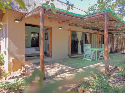 a patio of a house with a table and chairs at Hornbill House @ Zebula in Mabula