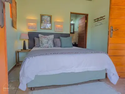 a bedroom with a large bed in a room at Hornbill House @ Zebula in Mabula