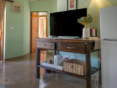 a television on top of a table with a basket at Hornbill House @ Zebula in Mabula