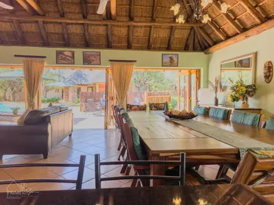 a dining room with a large wooden table and chairs at Hornbill House @ Zebula in Mabula