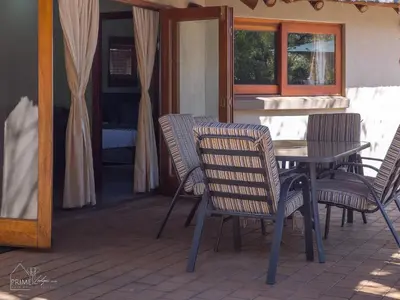 a table and chairs sitting on a patio at Hornbill House @ Zebula in Mabula