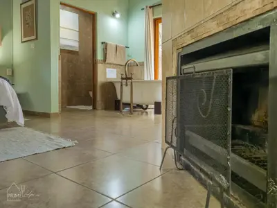 a living room with a fireplace and a tub at Hornbill House @ Zebula in Mabula