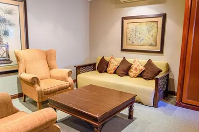 a living room with a couch and chairs and a table at RIETONDALE LODGE in Pretoria