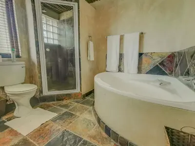 a bathroom with a toilet and a bath tub at Nyala's Corner @ Zebula in Mabula