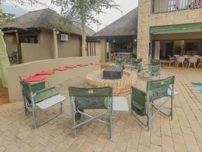 a group of chairs and a fire pit in a patio at Nyala's Corner @ Zebula in Mabula